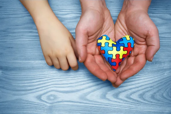 World Autism Dia de conscientização, quebra-cabeça ou quebra-cabeça padrão no coração com crianças autistas e mãos pai — Fotografia de Stock