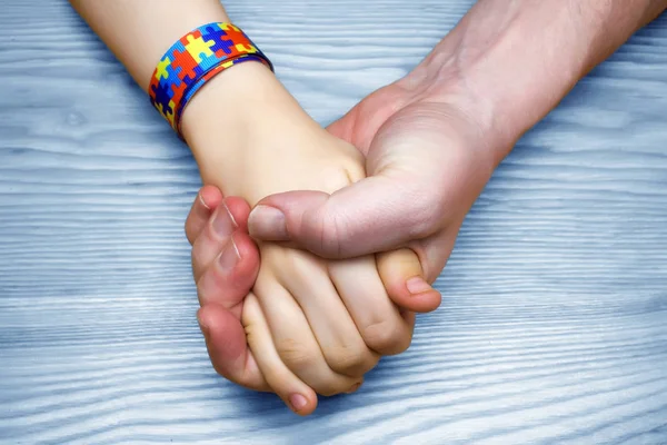Autismo Consapevolezza Immagine. Padre che tiene per mano il suo bambino autistico — Foto Stock