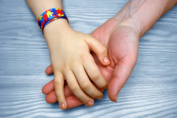 Imagem de Conscientização do Autismo. Pai de mão dada seu filho autista — Fotografia de Stock