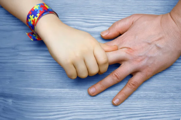 Αυτισμός ευαισθητοποίησης εικόνα. Ο πατέρας που κρατά το χέρι το αυτιστικό παιδί — Φωτογραφία Αρχείου