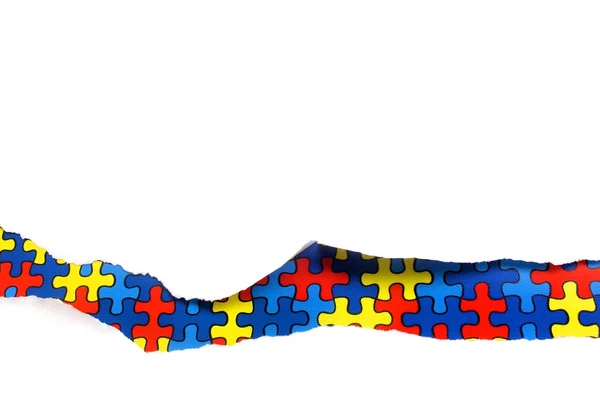 Torn white paper on multicolored puzzle background. Cocept for autism awareness day. Break barriers together for autism. — Stock Photo, Image