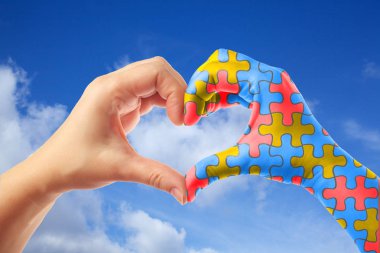 World Autism Awareness day, mental health care concept with puzzle jigsaw pattern on heart shape hands. clipart