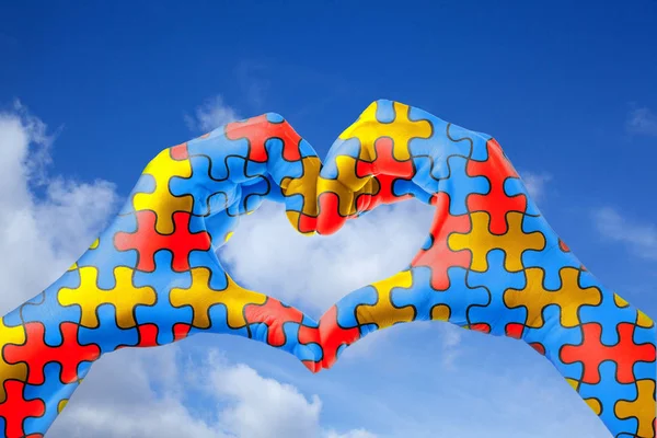 Día Mundial del Autismo, concepto de cuidado de la salud mental con patrón de rompecabezas en las manos en forma de corazón . —  Fotos de Stock