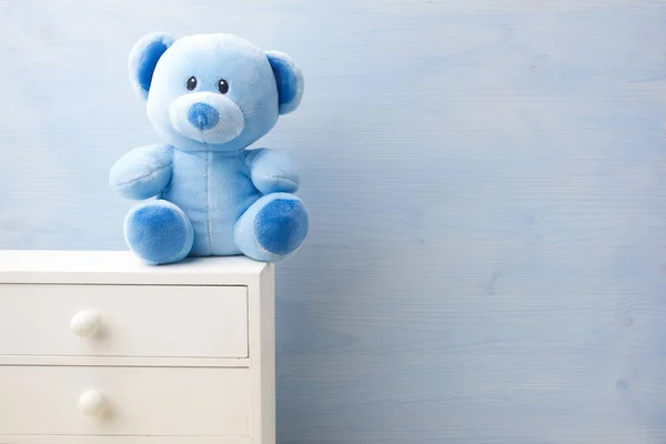 Pluszowy niedźwiedź zabawka samotnie na niebieskim tle — Zdjęcie stockowe