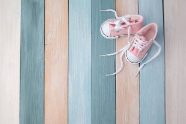 Metin için alan ile ahşap bir arka plan üzerinde Sevimli küçük bebek ayakkabıları