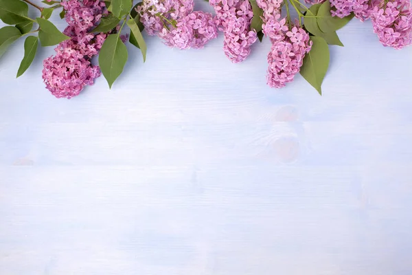 Lente lila bloemen op pastel houten achtergrond met Kopieer ruimte. Bovenaanzicht, vlakke lay — Stockfoto