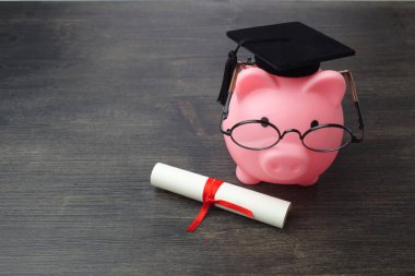 Tahta masa üzerinde yüksek lisans ve diploma ile Piggy banka, Eğitim bursu