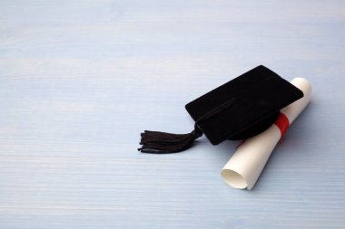 Açık mavi Ahşap Arka Plan Üzerinde Derece ile Siyah Mezuniyet Kapağı.