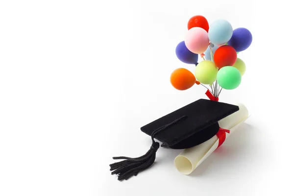 黑色毕业帽，学位和气球隔离在白色背景. 免版税图库照片