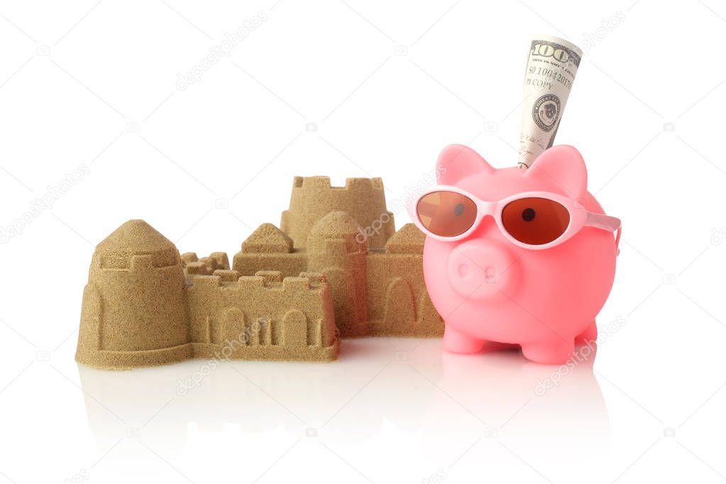 Piggy bank wearing retro sunglasses and sandcastle isolated on white background