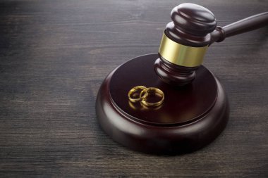 Koyu ahşap arka plan üzerinde bir yargıç alyans çekiç. Boşanma işlemleri