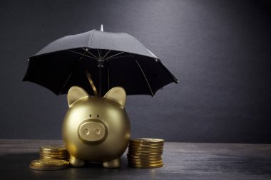 Finans sigortası, koruma, güvenli yatırım veya bankacılık için şemsiye konsepti ile altın Piggy Bankası