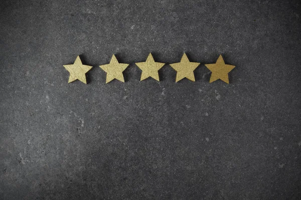 Five golden stars on dark background, top rating concept — Stock Photo, Image