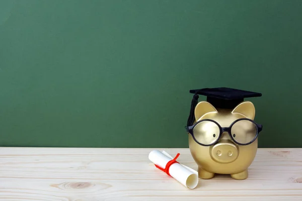 Gfold alcancía con una gorra de posgrado y diploma delante de pizarra verde. Beca de educación — Foto de Stock