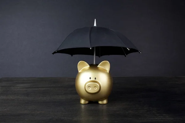 Gold Piggy bank with umbrella concept for finance insurance, protection, safe investment or banking — Stock Photo, Image