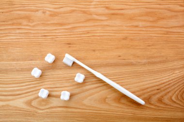 Ahşap arka plan üzerinde metin alanı ile küçük plastik diş ve diş fırçası ile Düz yatıyordu kompozisyon