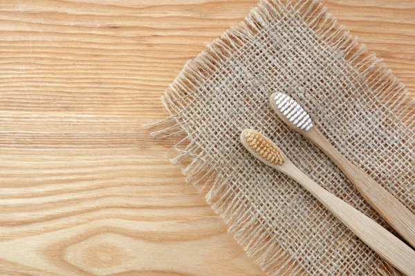 Zero conceito de desperdício. Escova de dentes de bambu em fundo de madeira. Essenciais livres de plástico, cuidado dos dentes . — Fotografia de Stock