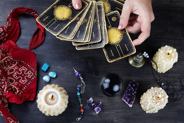 Wróżki ręce i karty tarota na ciemnym drewnianym stole. Koncepcja wróżenia. — Zdjęcie stockowe