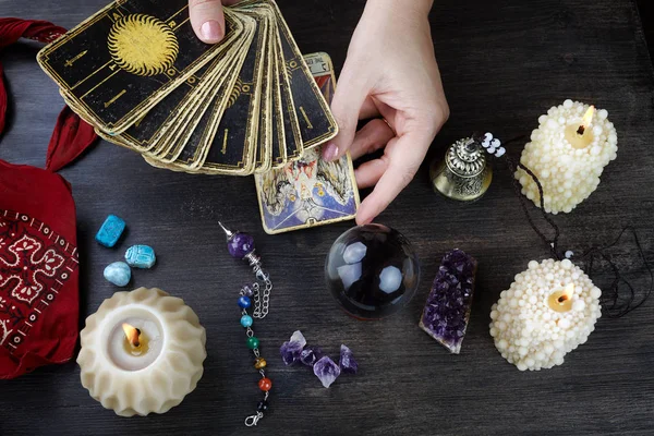 Fortune teller female hands and tarot cards on dark wooden table. Divination concept. — Stock Photo, Image
