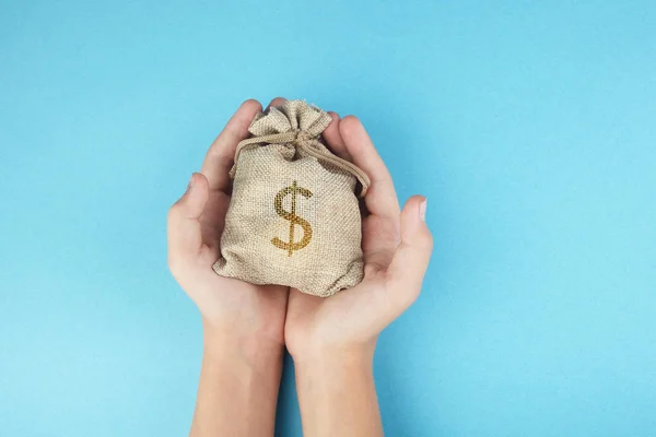 Жінки тримають сумку на синьому фоні, заощаджуючи гроші для майбутньої інвестиційної концепції . — стокове фото