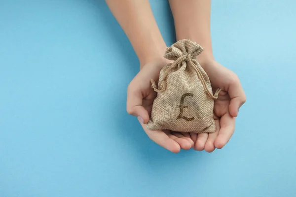 Женщины держат денежную сумку на синем фоне, экономя деньги на будущей инвестиционной концепции . — стоковое фото