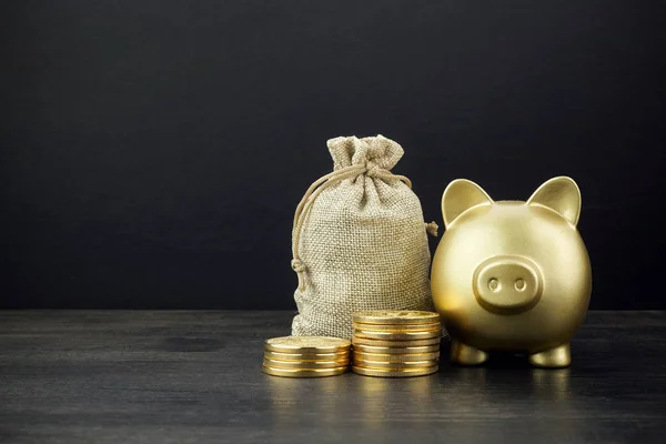 Piggy Bank y bolsa de dinero con monedas sobre fondo de madera oscura — Foto de Stock