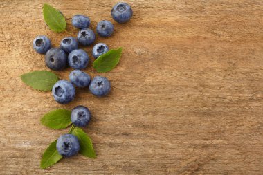 Beyaz ahşap arka planda yaprakları ile taze ham yaban mersini. Organik gıda