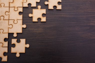 Koyu ahşap arka plan üzerinde eksik yapboz bulmacalar