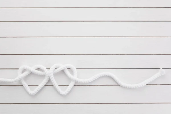 Węzeł w kształcie serca na białym tle drewnianym — Zdjęcie stockowe