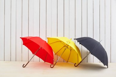 Tasarım alanı ile beyaz ahşap duvar yakınında katta üç şemsiye