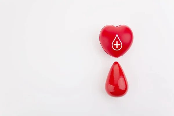 Dare sangue salva la vita. Concetto di donazione di sangue. Cuore rosso e goccia di sangue su sfondo bianco — Foto Stock