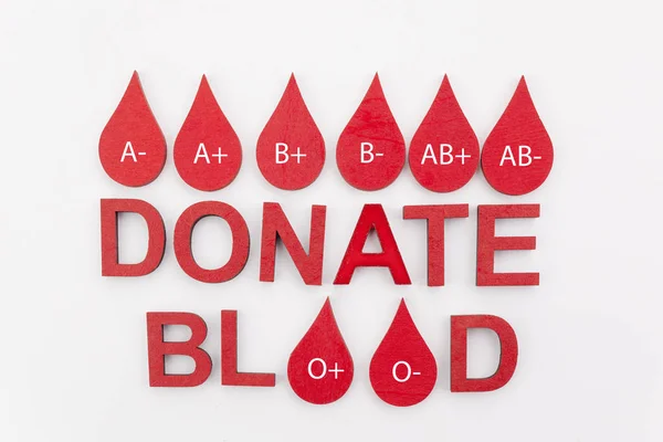 Deixa cair o conceito de doação de sangue. Texto doar sangue com gotas vermelhas sobre fundo branco — Fotografia de Stock