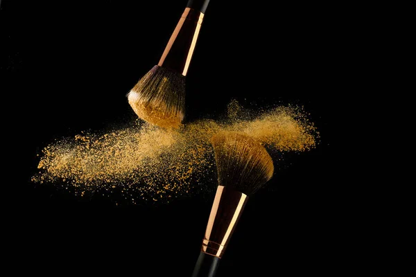 Siyah arka plan üzerinde yayılan altın tozu ile Kozmetik fırça — Stok fotoğraf
