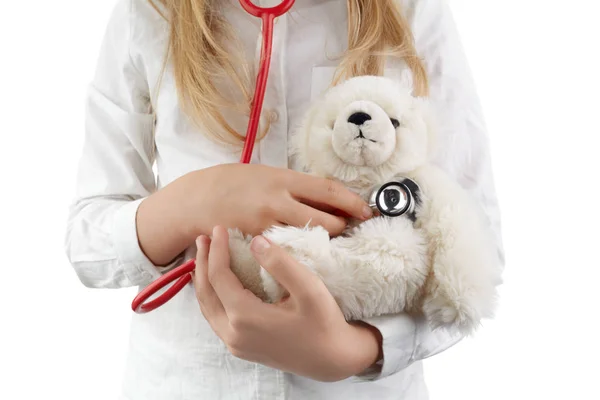 Niña jugando doctor con peluche juguete como guardería sobre fondo blanco —  Fotos de Stock