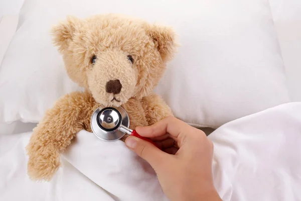 Teddy Bear está enfermo en la cama sobre fondo blanco —  Fotos de Stock