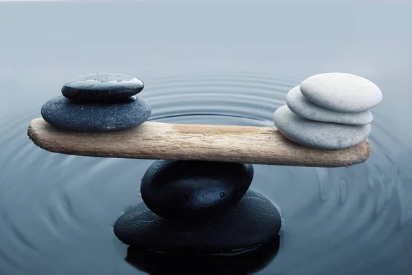 Zorgvuldig uitgebalanceerde zwarte en witte stenen in water — Stockfoto