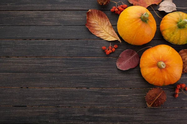 Calabazas y hojas caídas sobre fondo de madera. Halloween, Día de Acción de Gracias o fondo estacional — Foto de Stock