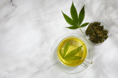 Kenevir bitki çayı. Hafif arka planda kenevir yapraklı sıcak içecek.