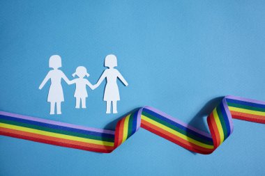Homoseksüel aile. Farklı bir aile. Kağıt yağmur kurdelesiyle aile simgesini kesti