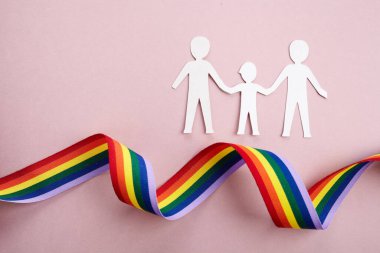 Homoseksüel aile. Farklı bir aile. Kağıt yağmur kurdelesiyle aile simgesini kesti