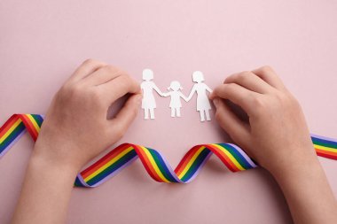 Homoseksüel aile. Farklı bir aile. Kağıt yağmur kurdelesiyle aile simgesini kesti
