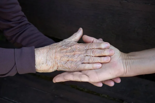 Starzy i młodzi trzymają się za ręce. Rodzinna koncepcja miłości. Środowisko opieki zdrowotnej. — Zdjęcie stockowe
