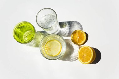 Gölgeli ve limonlu modern bardaklar. Yaz durgun hayat sahnesi