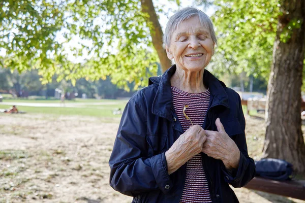 Uma mulher de noventa anos está sorrindo no parque. — Fotografia de Stock