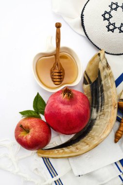 Görüntü: Nar, elma, bal ve beyaz bir zemin üzerinde Yahudi dua şalıyla birlikte Shofar..