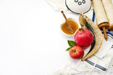 Beyaz arka planda şah, elma, bal, nar ve dua şalı içeren Rosh Hashanah sembolleri.