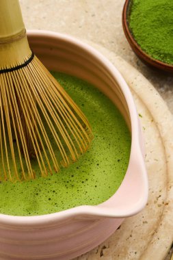 Geleneksel bambu çırpıcısının köpüklü yeşil bir kibrit kutusundaki yakın çekimi, sakinleştirici, doğal bir atmosferi çağrıştırıyor..