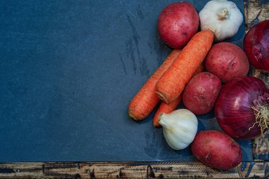 Çiğ sebzeler ve ahşap masa, sağlıklı ve doğal bir şekilde pişirmek için.