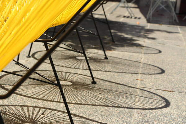 Shadows cast by a row of Acapulco outdoor chairs