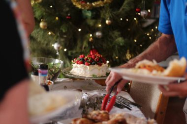 Krema ve böğürtlenli Pavlova klasik bir Avustralya tatlısıdır. Yılbaşı aile büfesi Noel ağacıyla ışıklar ve mücevherlerle dolu.